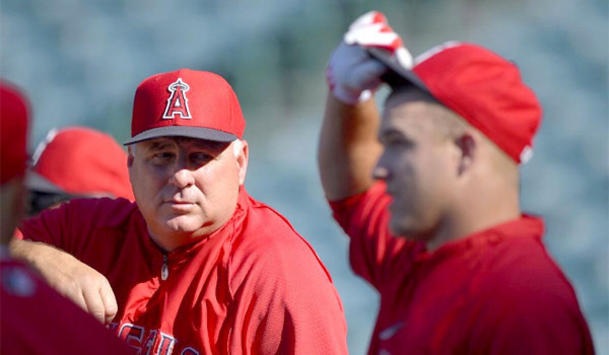 Mike Trout, right, won't be participating in the Home Run Derby this year, an event Manager Mike Scioscia, left, likened to "hitting 10 buckets of balls" at a driving range.