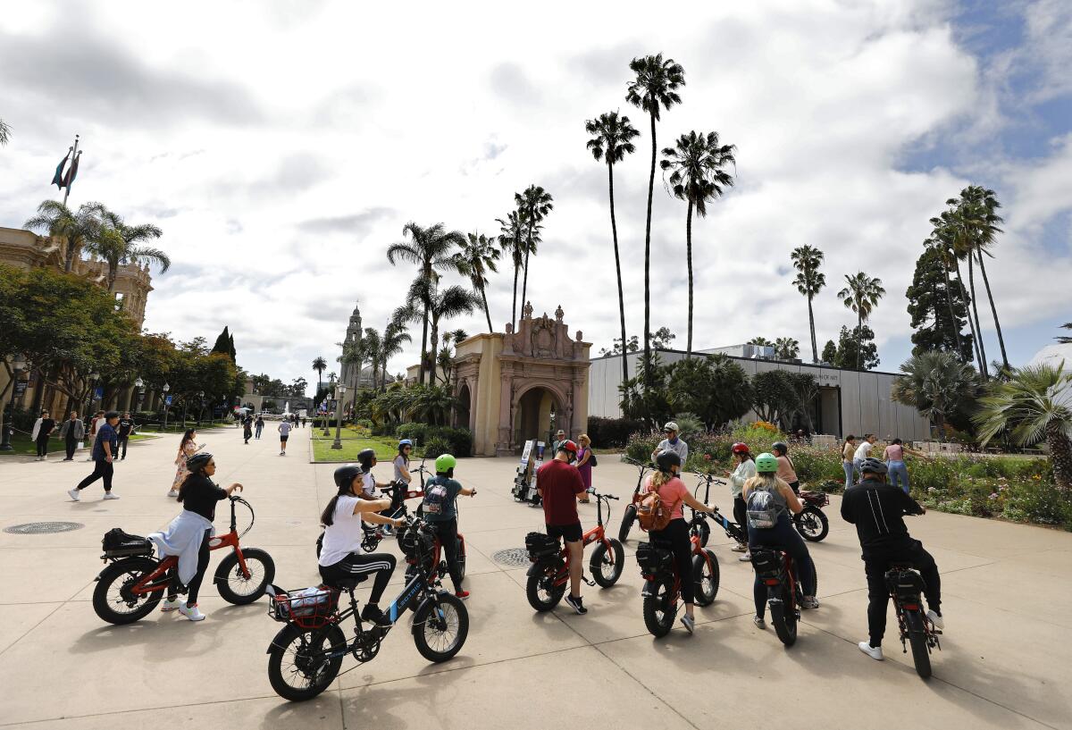 People take an electric bike tour through Balboa Park.