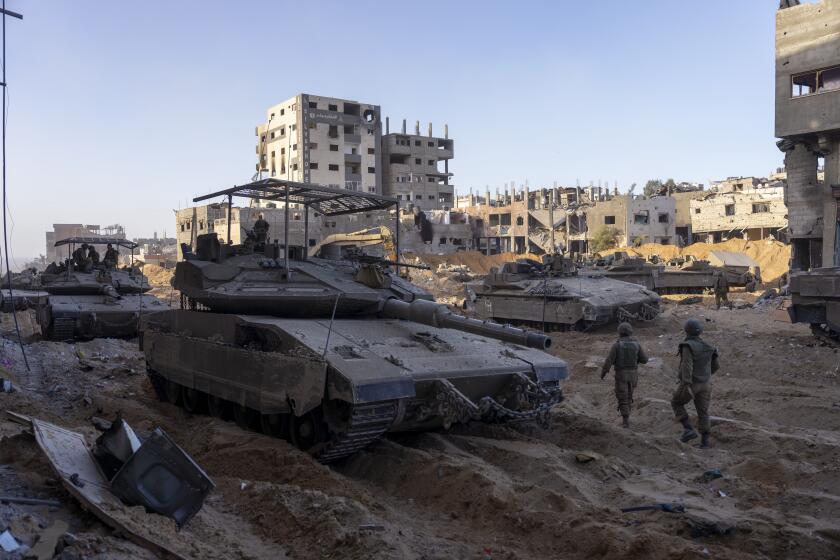 Israeli army troops are seen next to a destroyed building during a ground operation in the Gaza Strip on Wednesday, Nov. 8, 2023., Wednesday, Nov. 8, 2023. Israeli ground forces entered the Gaza Strip as they press ahead with their war against Hamas militants in retaliation for the group's unprecedented Oct. 7 attack on Israel. (AP Photo/Ohad Zwigenberg)