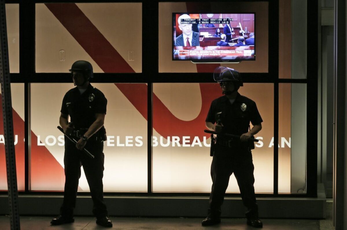 LAPD officers stand outside the CNN building, where as many as 200 people gathered Sunday to protest the not guilty verdict in the trial of George Zimmerman.