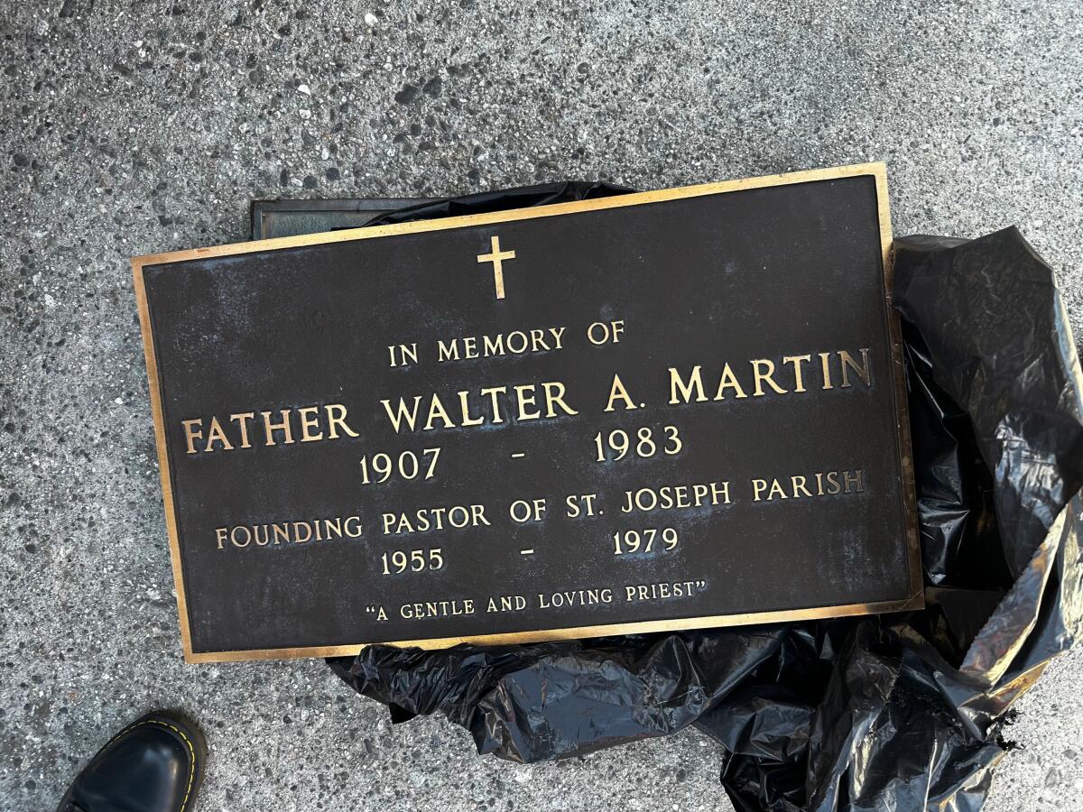 A metal plaque on the ground says "In memory of Father Walter A. Martin."