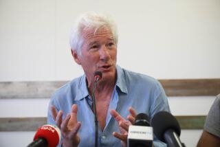 Actor Richard Gere gestures as he speaks during a press conference he held along with Open Arms founder Oscar Camps, in the island of Lampedusa, Southern Italy, Saturday, Aug. 10, 2019, the day after he visited the Spanish humanitarian ship that has been stuck at sea with 121 migrants on board for over a week, after Italy and Malta have denied it entry. The Open Arms boat has rescued 39 more migrants on Saturday morning. (AP Photo/Valerio Nicolosi)