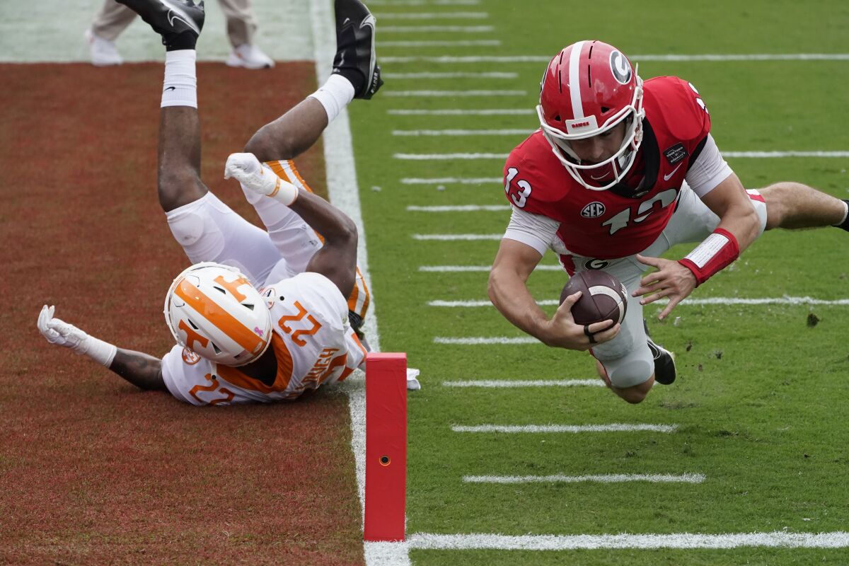 Georgia quarterback Stetson Bennett (13) dives past Tennessee defensive back Jaylen McCollough (22) to score a touchdown in the first half of an NCAA college football game Saturday, Oct. 10, 2020, in Athens, Ga. (AP Photo/John Bazemore)