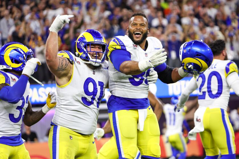 Los Angeles Rams defensive end Aaron Donald, right, celebrates his sack of Cincinnati Bengals quarterback Joe Burrow