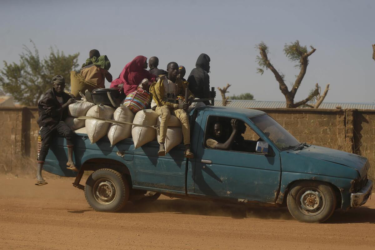People travel past Government Science Secondary School in Kankara, Nigeria.