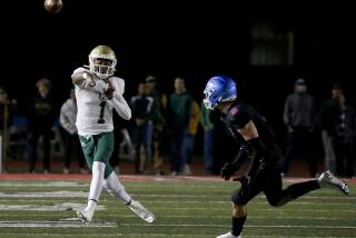 LONG BEACH, CALIF. - NOV. 11, 2022. Long Beach Poly quarterback Darius Curry throws on the run against Los Alamitos. in the first half of a CIF Division 1 playoff game at Veterans Stadium in Long Beach on Friday night, Nov. 11, 2022. (Luis Sinco / Los Angeles Times)