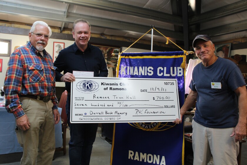 Woody Kirkman, president of the Ramona Town Hall trustees, accepts a $700 check from Kiwanis Club for building renovation. 
