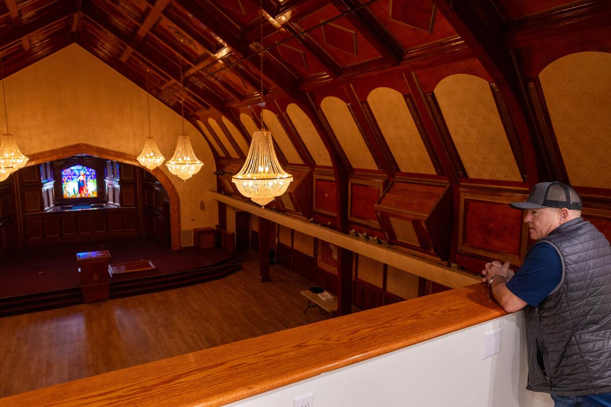 A man surveys what used to be a church sanctuary from the balcony.  