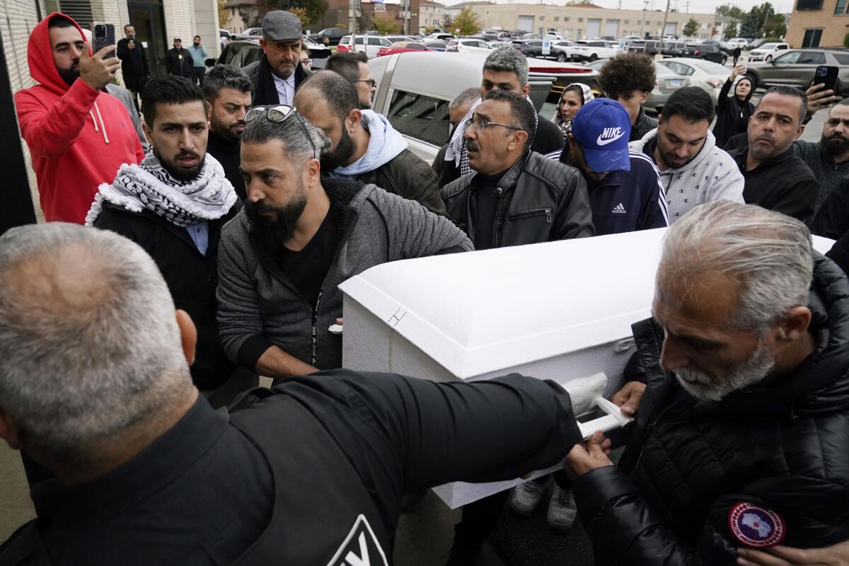 Family members of Wadea Al-Fayoume carry his small white casket into Mosque Foundation in Bridgeview, Ill.