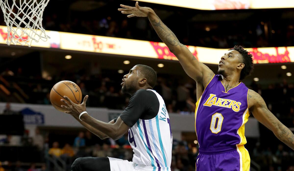 The Charlotte Hornets' Michael Kidd-Gilchrist drives to the basket as the Lakers' Nick Young goes for a block during Tuesday's game.