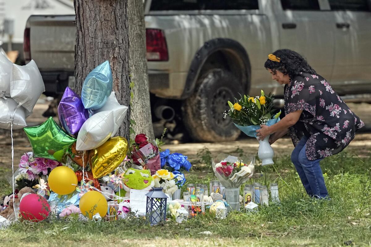 Maria Rodriguez places flowers outside a home where a mass shooting took place.