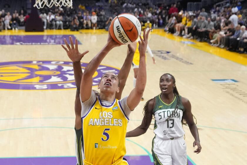 Los Angeles Sparks forward Dearica Hamby, center, shoots as Seattle Storm forward Nneka Ogwumike, left, and center Ezi Magbegor defend during the first half of a WNBA basketball game, Wednesday, Sept. 11, 2024, in Los Angeles. (AP Photo/Mark J. Terrill)