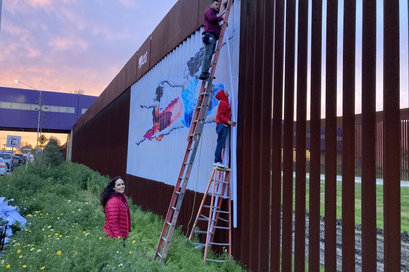 La artista Alejandra Phelts observa mientras montan su obra Bird Women sobre el muro fronterizo el 6 de marzo de 2023. 