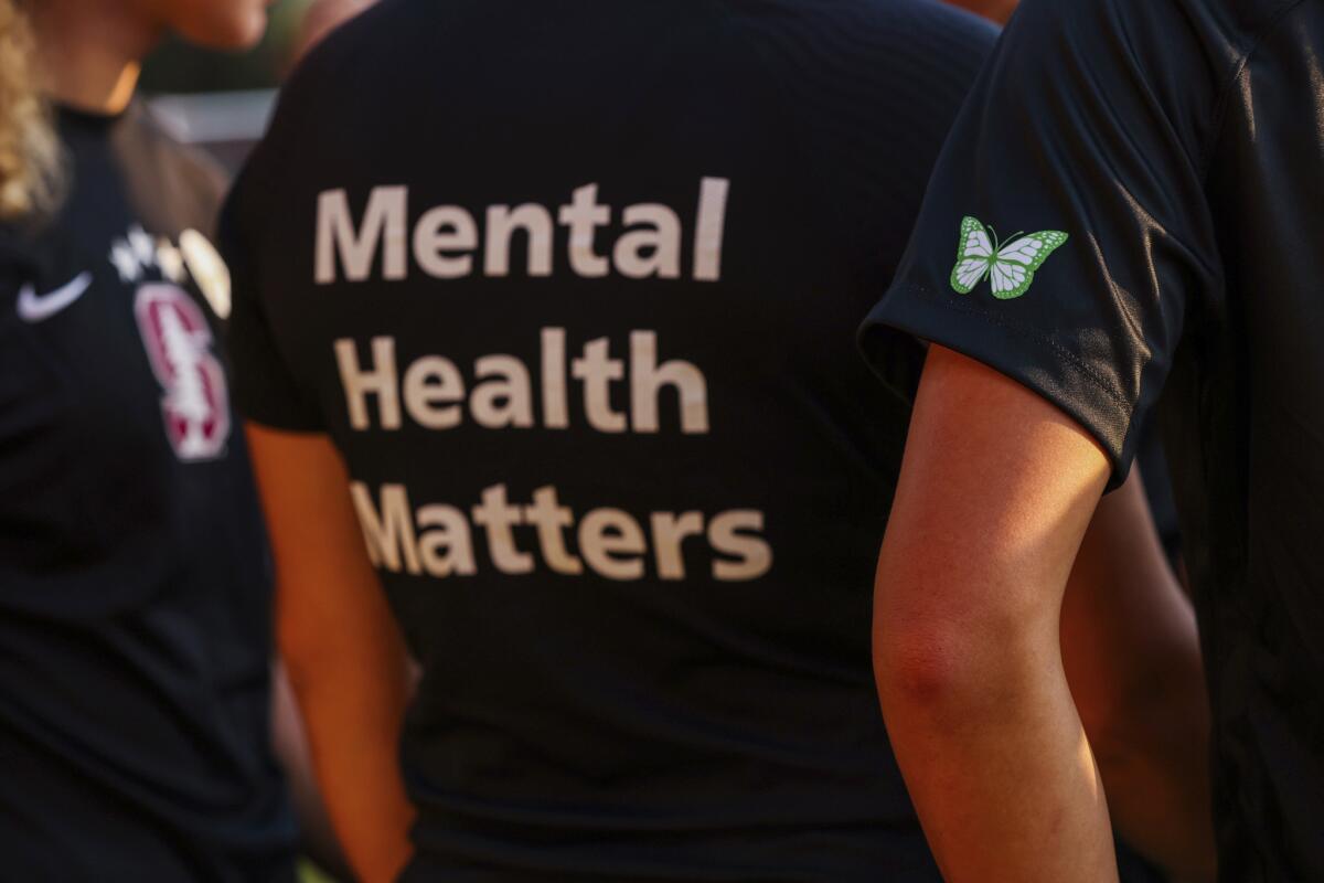 Players on the Stanford women's soccer team wear warmup jerseys with "Mental Health Matters" on their backs.