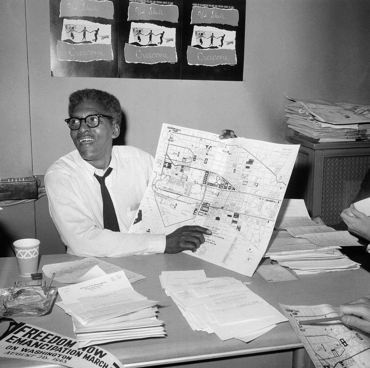 FILE - Bayard Rustin, deputy director of the planned march on Washington program, points to a map showing the line of march for the demonstration for civil rights during a news conference in New York on Aug. 24, 1963. (AP Photo, File)