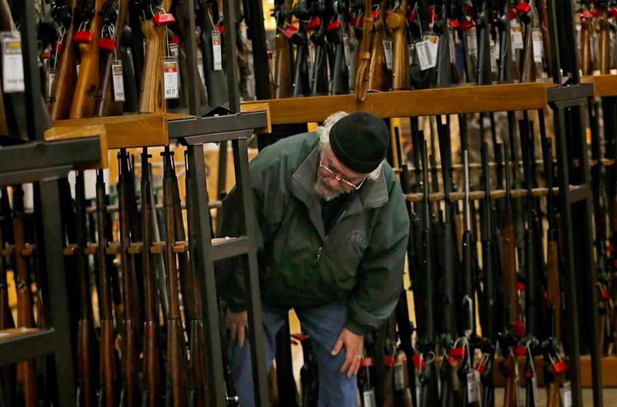 Un hombre observa la sección de fusiles en la tienda Cabela’s en Hazelwood, Missouri.