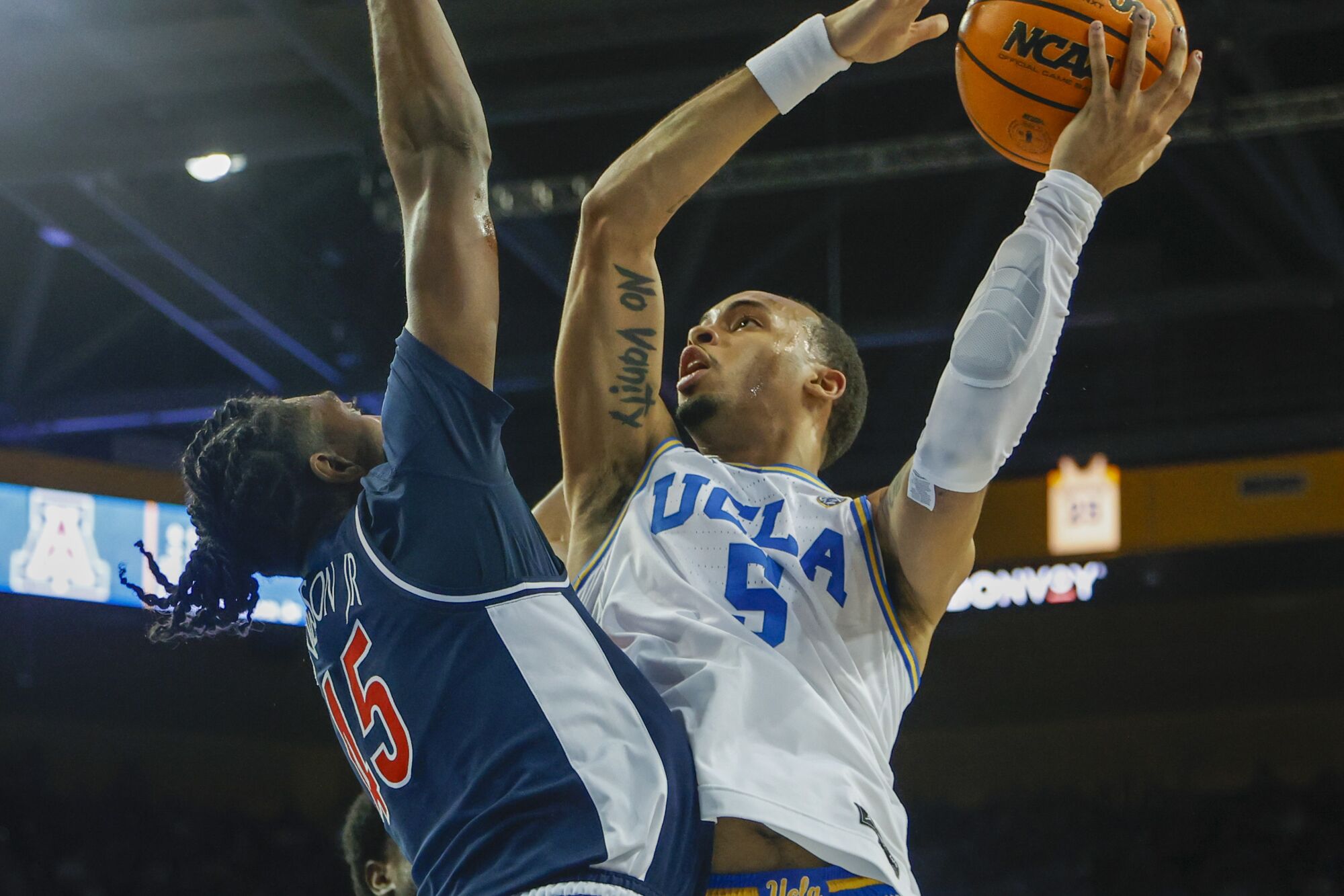 UCLA guard Amari Bailey shoots Arizona's Cedric Henderson Jr.