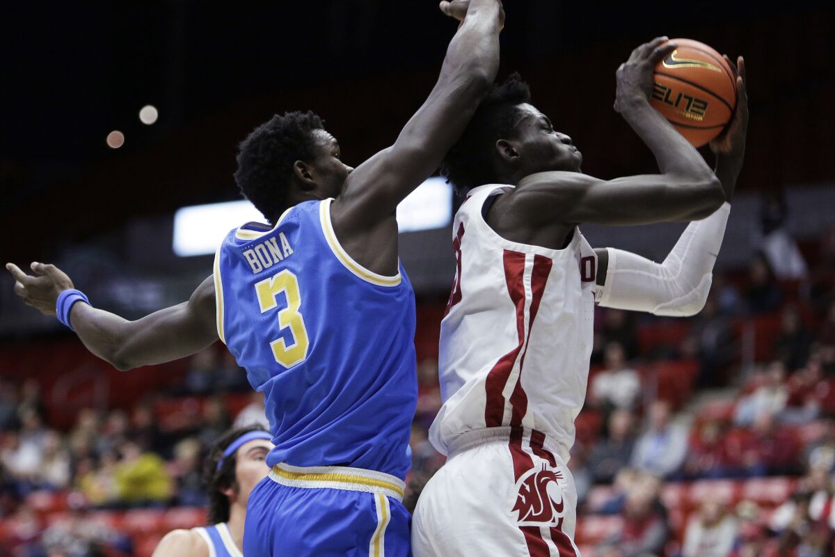 Washington State forward Mouhamed Gueye, right, grabs a rebound in front of UCLA forward Adem Bona.
