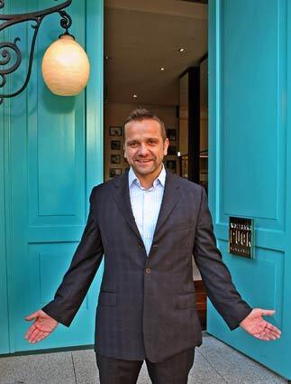 Klaus Puck, operations partner and brother of Wolfgang Puck, greets visitors at the front door of Wolfgang Puck Bar & Grill at L.A. Live in downtown Los Angeles.