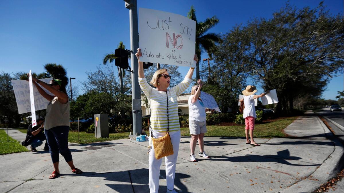 Cathy Kuhns, a teacher, stands on a street corner holding up anti gun signs in Parkland, Fla., on Feb. 17.