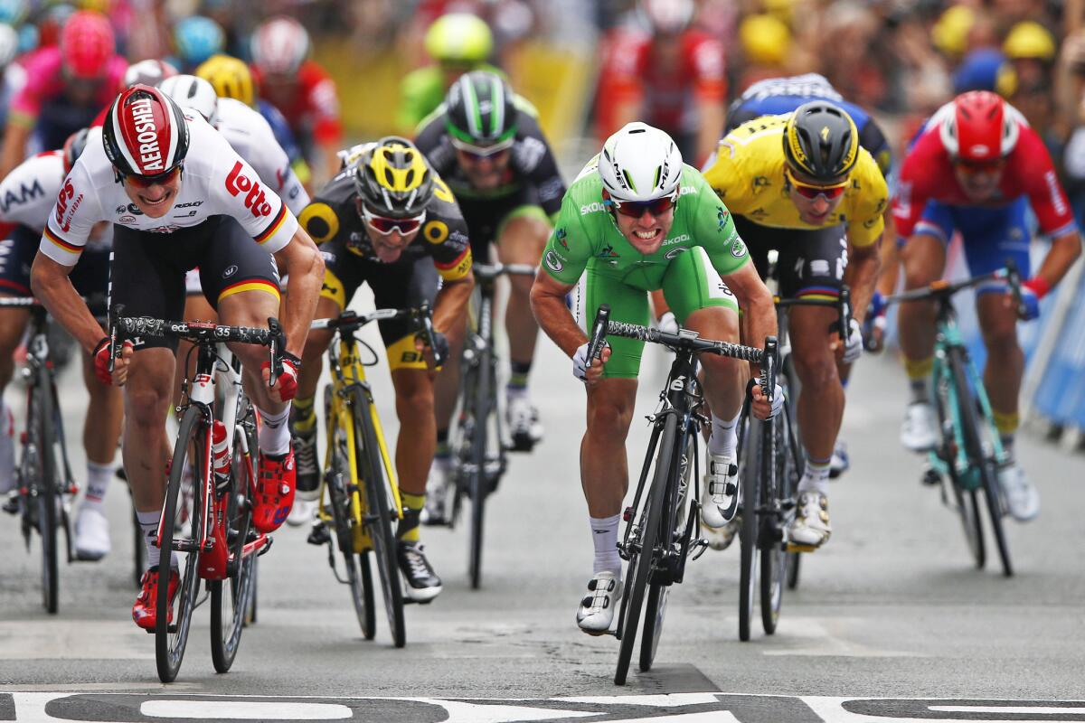 Britain's Mark Cavendish, wearing the best sprinter's green jersey, crosses the finish line ahead of Germany's Andre Greipel, left, and Peter Sagan of Slovakia, wearing the overall leader's yellow jersey, to win the third stage of the Tour de France.