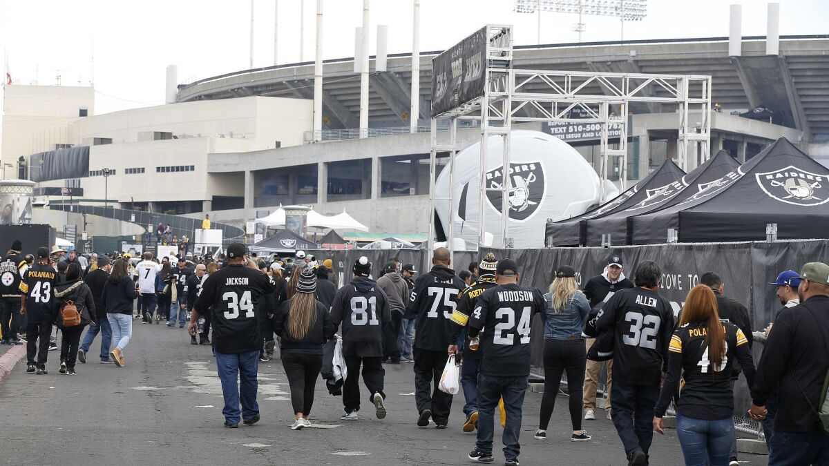Fans tailgate outside of Oakland Alameda County Coliseum before a game between the Oakland Raiders and the Pittsburgh Steelers.