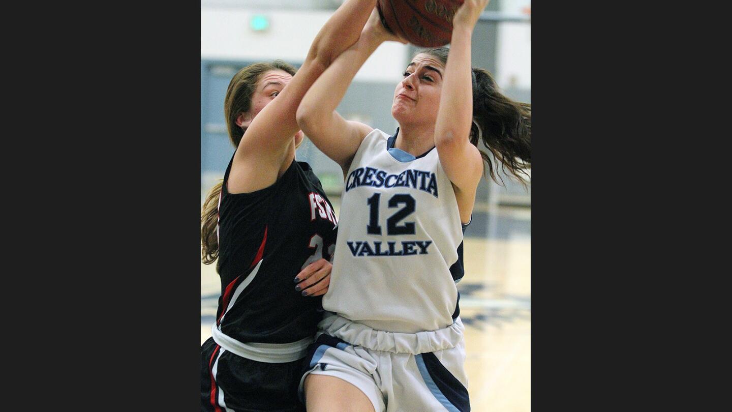 Crescenta Valley's Kaitlyn Jabourian drives and shoots against the defense of Flintridge Sacred Heart's Tori Conlon in the Crescenta Valley Classic girls' basketball tournament game at Crescenta Valley High School on Tuesday, November 29, 2016.