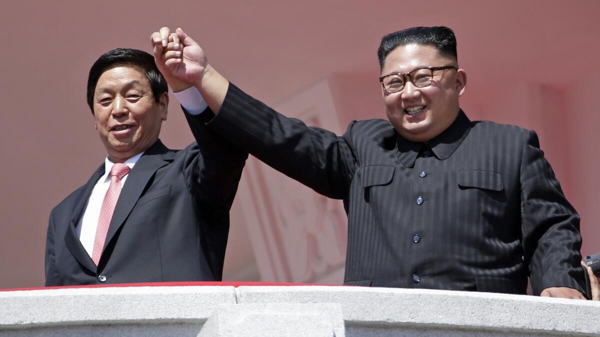Li Zhanshu, left, the Chinese Community Party's third-ranking member, joins hands with North Korean leader Kim Jong Un.