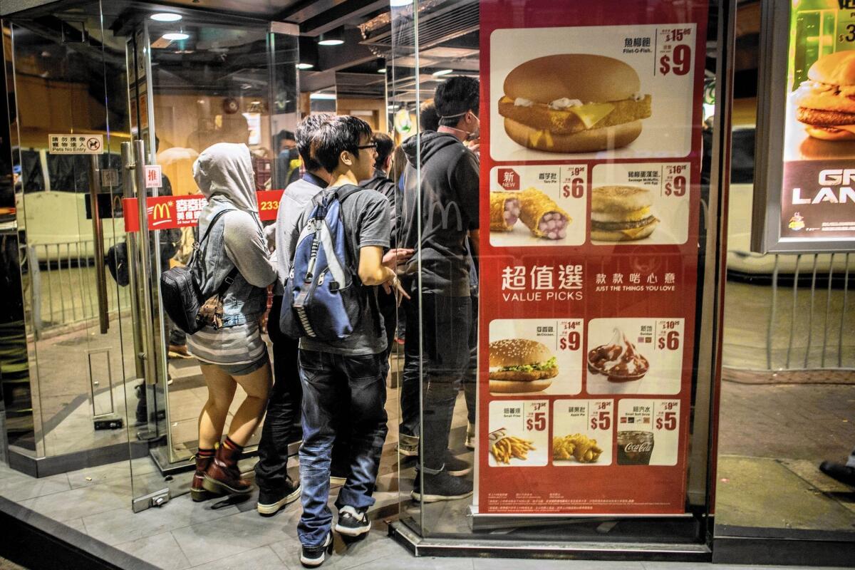 Student protesters duck into a McDonald's to dodge police in Hong Kong's Mong Kok district, where protests encampments have been demolished.