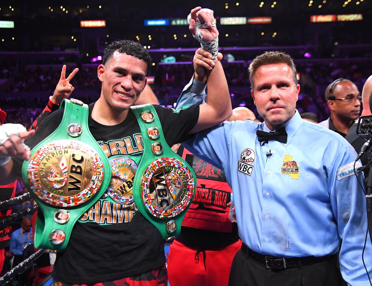 Referee Thomas Taylor with David Benavidez in the ring after defeating Anthony Dirrell (not  pictured) after a corner stoppage in their WBC Super Middleweight Championship fight at Staples Center on Saturday.