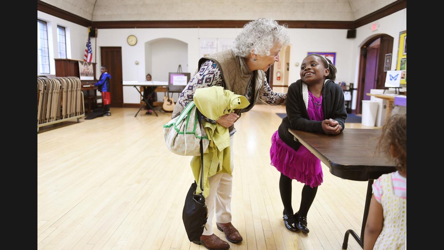 Maua Shukrani, 8, is greeted by church member Charlotte Orr at Holy Spirit Church in Missoula, Monta