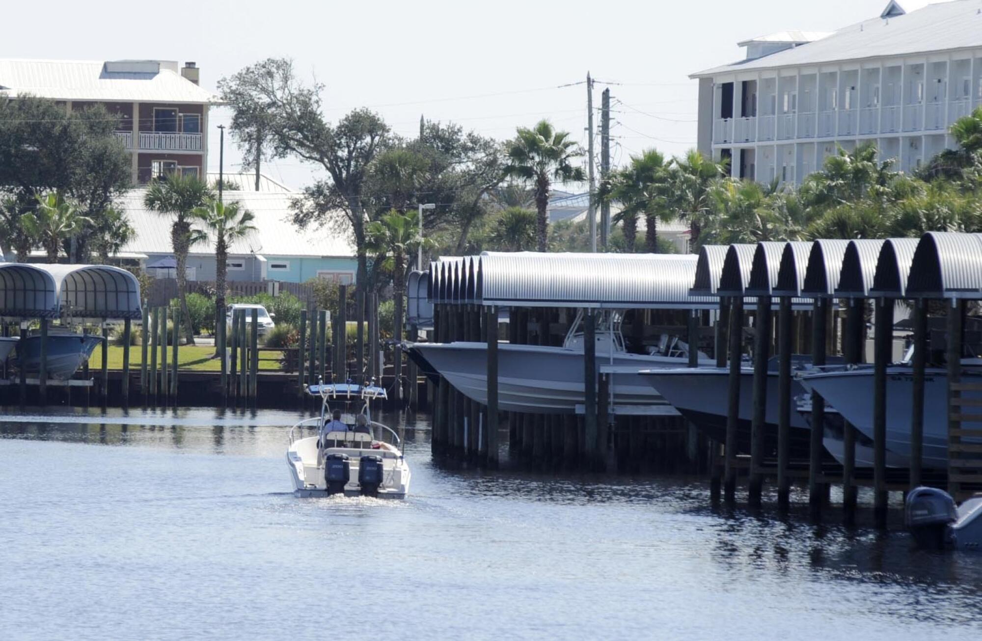 A boat cruises through a marina in rebuilt Mexico Beach, Fla.