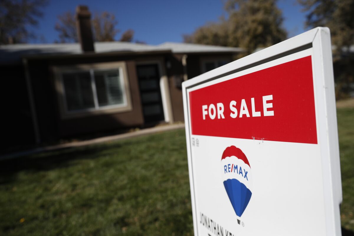 In this Oct. 22, 2019 file photo, a sign stands outside a home for sale in southeast Denver. 