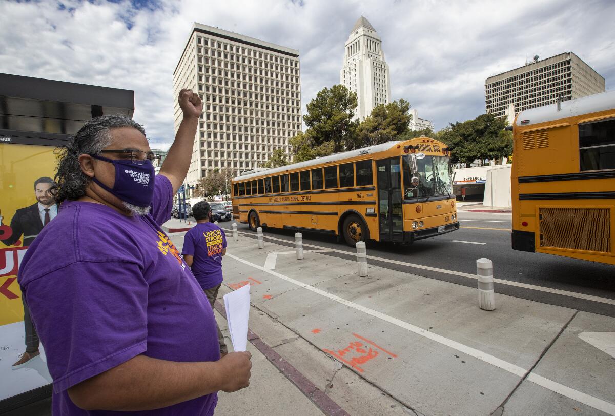 Union leader Max Arias cheers as school buses drive past.
