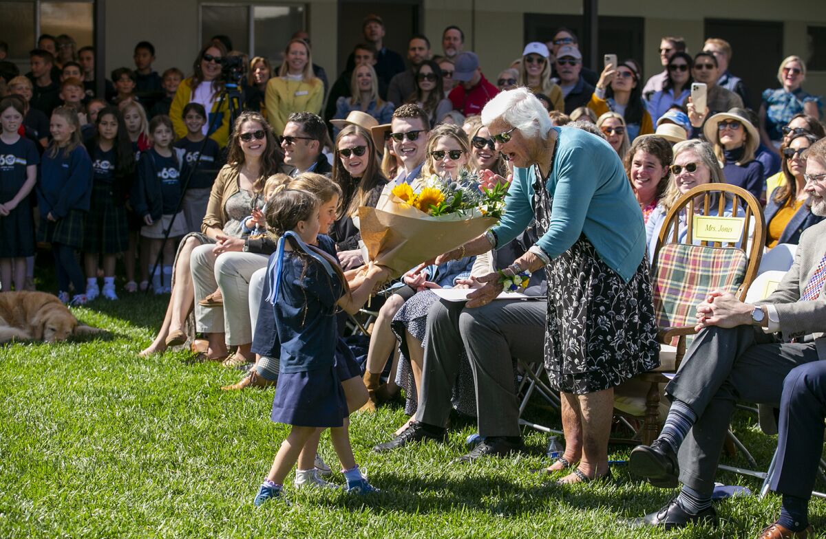 Kindergartener's Mara McDonough, left, and Lucille Newquist present flowers to Jane Jones.