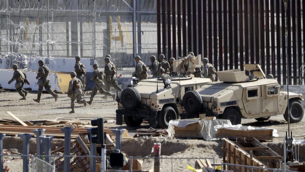 Officials run in a staging area in the San Ysidro port of entry at the U.S.-Mexican border on Sunday.