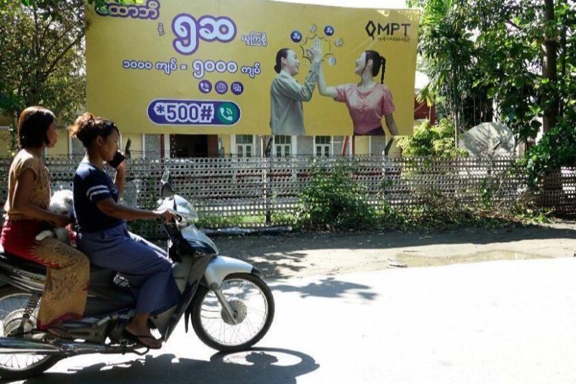 Mandatory Credit: Photo by NYUNT WIN/EPA-EFE/REX (10319129d) Two Rakhine women ride a motorcycle past a telecommunications advertisement poster in Sittwe, Rakhine state, Myanmar, 22 June 2019. According to reports, a temporary band of internet data services was announced for some conflict areas in Rakhine state. Fighting continues between Myanmar military troops and the Arakan Army in Rakhine State. About 40,000 residents have fled the village's into temporary camps in Ponnagyun, Buthidaung, Rathetaung, Mrauk U, Min Bya, Sittwe and Kyauktaw townships. Temporarily banned internet data services in Rakhine state, Sittwe, Myanmar - 22 Jun 2019 ** Usable by LA, CT and MoD ONLY **