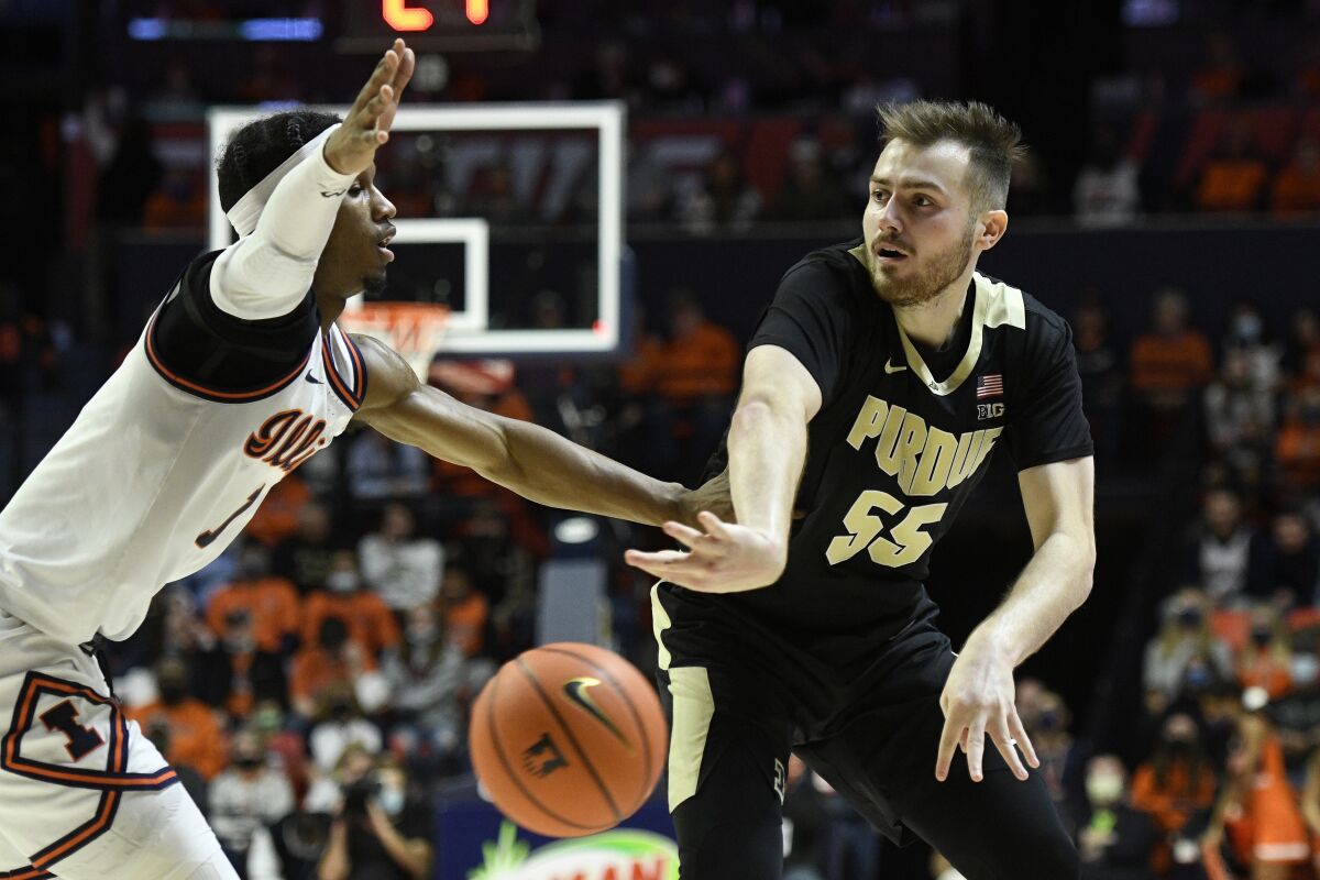 Purdue's Sasha Stefanovic (55) passes as Illinois' Trent Frazier defends during the second half of an NCAA college basketball game, Monday, Jan. 17, 2022, in Champaign, Ill. (AP Photo/Michael Allio)