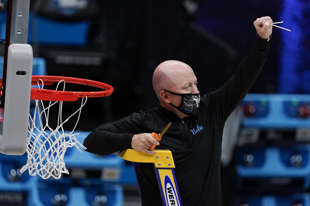 UCLA head coach Mick Cronin cuts down the net after an Elite 8 victory over Michigan.