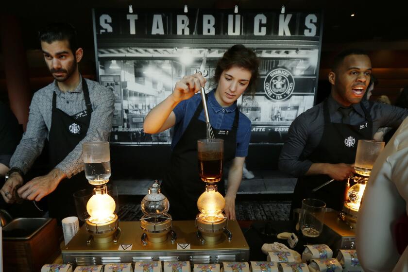 Starbucks workers prepare coffee during the company's annual shareholders meeting in Seattle in March.