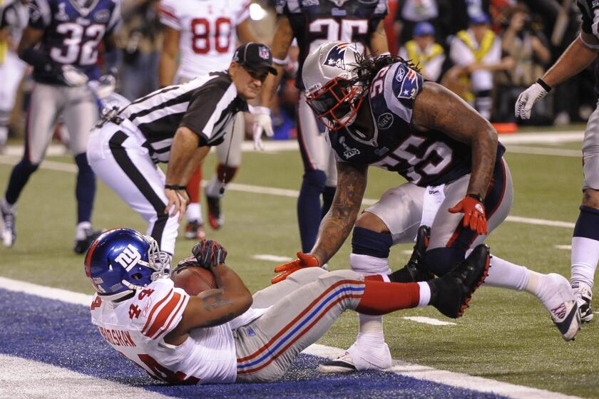 Ahmad Bradshaw, left, of the New York Giants scores a game-winning touchown late in the fourth quarter against the New England Patriots during Super Bowl XLVI.