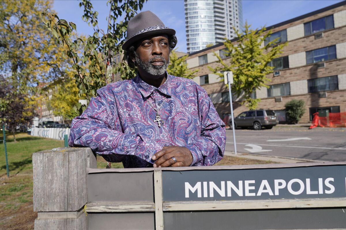 Terrance Jackson stands behind a Minneapolis sign.