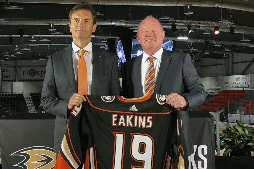 FILE - In this Monday, June 17, 2019 file photo, Anaheim Ducks head coach Dallas Eakins, left, and general manager Bob Murray pose with a jersey at Great Park Ice in Irvine, Calif. General manager Bob Murray saw intermittent signs of progress from his young Ducks players and first-year coach Dallas Eakins while Anaheim missed the playoffs for the second consecutive season. (AP Photo/Greg Beacham, File)