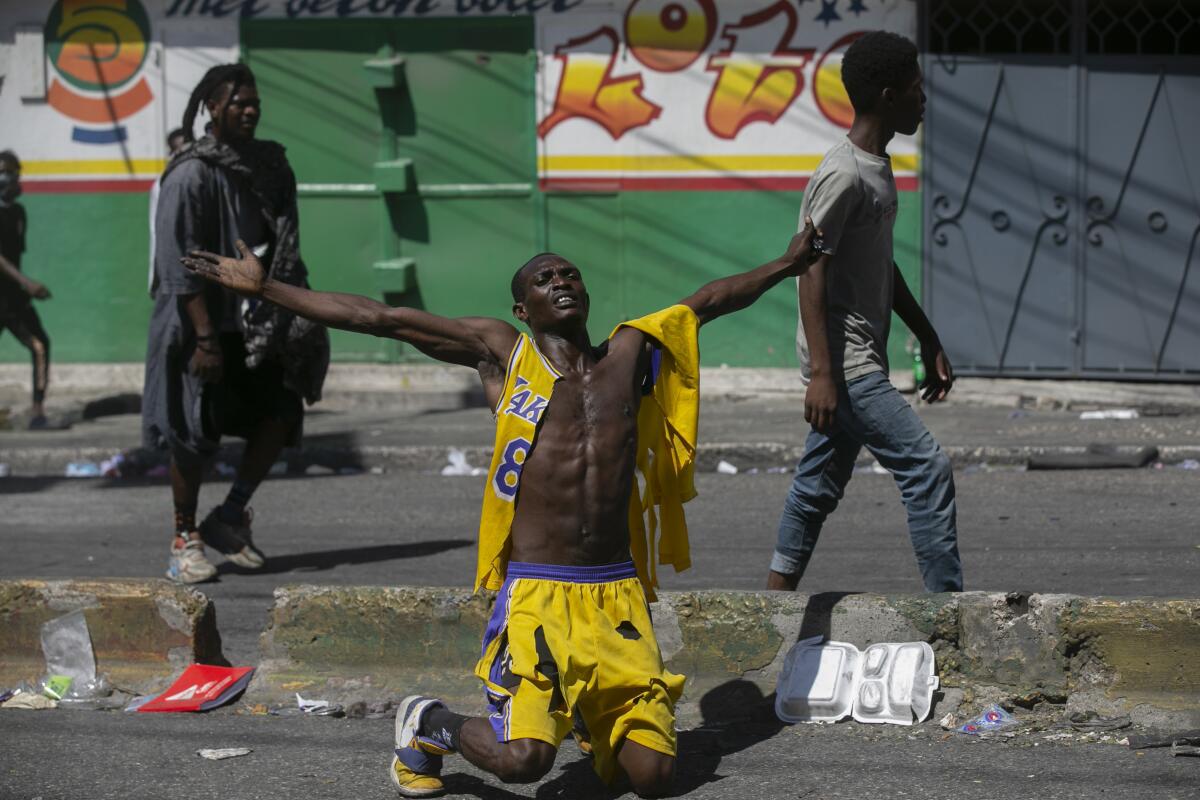 A protester kneels while chanting "Justice for the people!" during a protest against fuel price hikes and to demand that Haitian Prime Minister Ariel Henry step down, in Port-au-Prince, Haiti, Thursday, Sept. 15, 2022. (AP Photo/Odelyn Joseph)