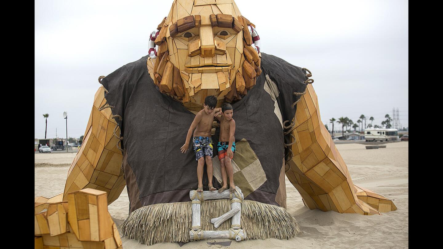 Luke Grove, 10, and his brother Brycen, 8, climb on a Giant from the game "Clash of Clans" on Aug. 25 at Huntington State Beach.