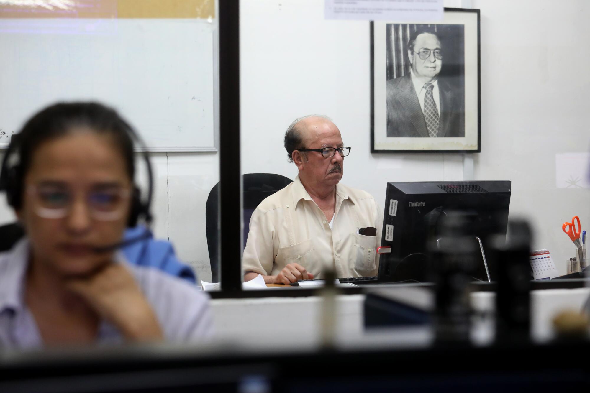 El editor de la página editorial Luis Sánchez Sancho trabajando. Detrás de él hay un retrato de Pedro Joaquín Chamorro, el antiguo editor de La Prensa que fue asesinado en 1978.