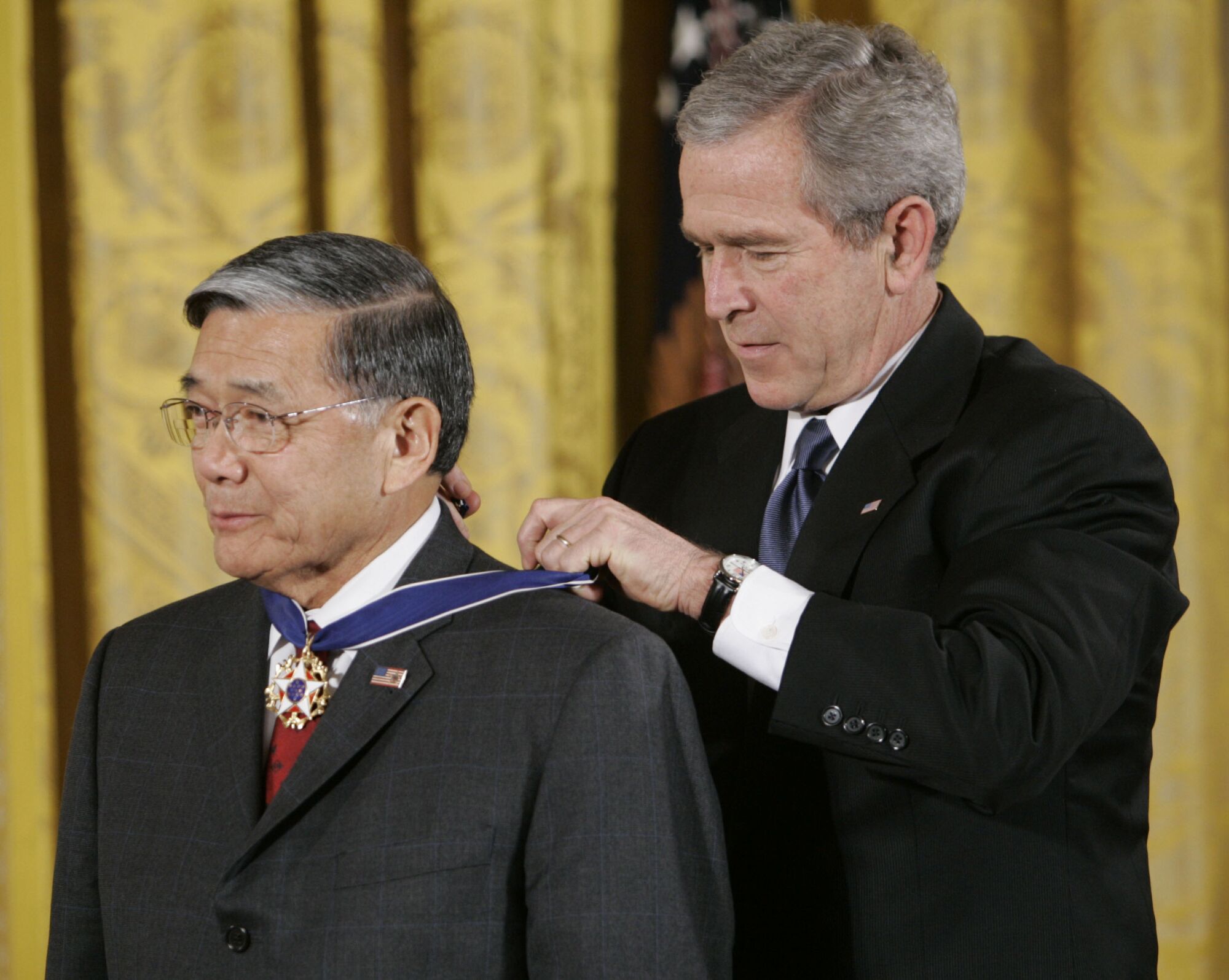 Der damalige Präsident George W. Bush (rechts) überreicht Norman Mineta die Freiheitsmedaille des Präsidenten.