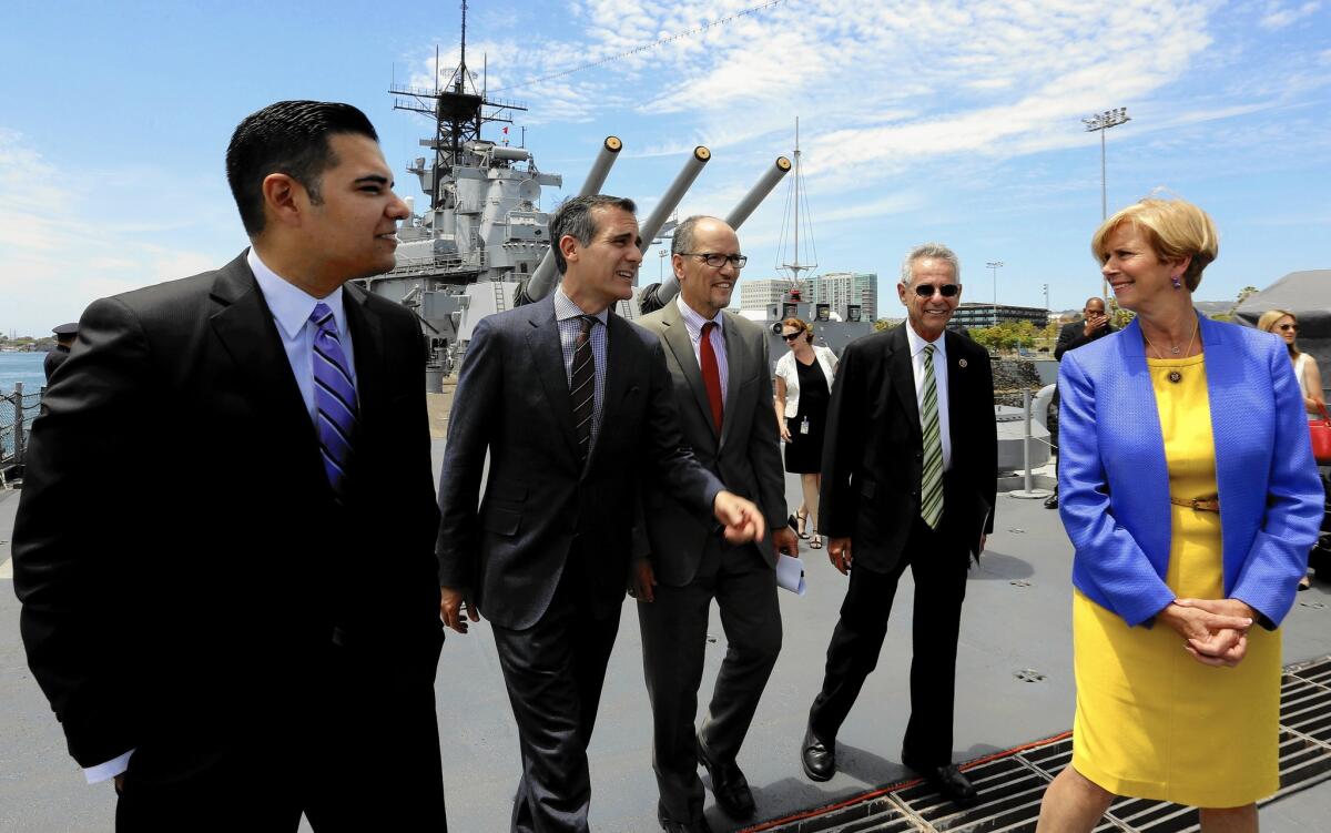 Long Beach Mayor Robert Garcia, left, Los Angeles Mayor Eric Garcetti, Labor Secretary Thomas E. Perez, Rep. Alan Lowenthal (D-Long Beach) and Rep. Janice Hahn (D-Los Angeles) walk to a news conference on the battleship Iowa in San Pedro.