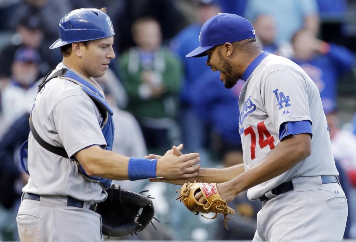 Kenley Jansen celebrates his 43rd save of the season with catcher A.J. Ellis. The Dodgers beat the Cubs, 8-5, on Sunday at Wrigley Field.