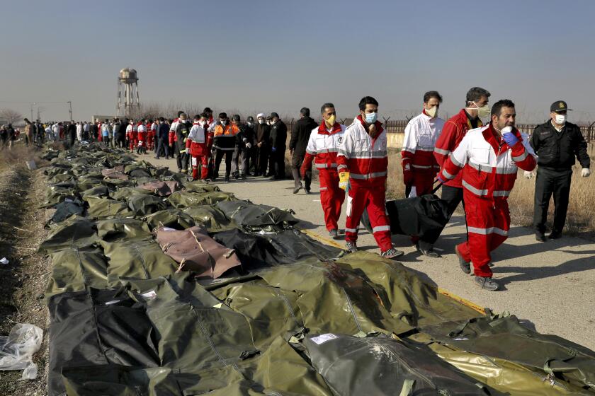 FILE - Rescue workers carry the body of a victim of a Ukrainian plane crash in Shahedshahr, southwest of the capital Tehran, Iran, Wednesday, Jan. 8, 2020. The United Kingdom, Canada, Sweden and Ukraine launched a case against Iran at the United Nations' highest court Wednesday, July 5, 2023, over the downing in 2020 of a Ukrainian passenger jet and the deaths of all 176 passengers and crew. (AP Photo/Ebrahim Noroozi, File)